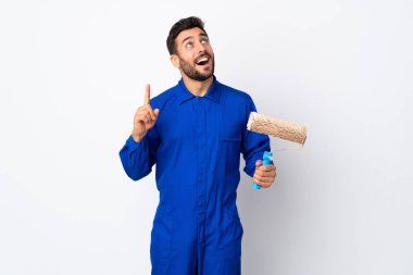 Beyaz arka planda izole edilmiş bir boya silindiri tutan ressam yukarı bakıyor ve şaşırıyor.