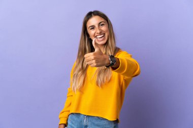 Soyutlanmış mor bir geçmişi olan genç İspanyol bir kadın. Başparmakları havada çünkü iyi bir şey oldu.