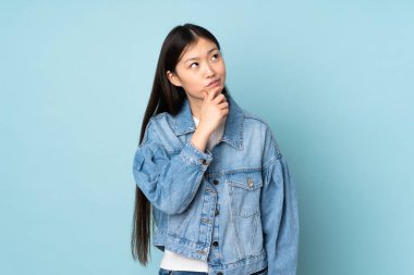 Asyalı genç bir kadın arka planda mahsur kalmış. Şüpheleri var.