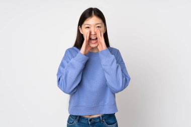 Genç Asyalı kadın arka planda izole edilmiş bağırıyor ve bir şey duyuruyor.