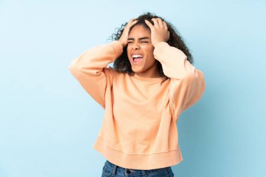 Genç Afrikalı Amerikalı kadın mavi arka planda izole edilmiş.