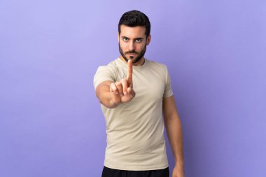 Sakallı, soyutlanmış bir geçmişi olan genç ve yakışıklı bir adam parmağını kaldırıyor.