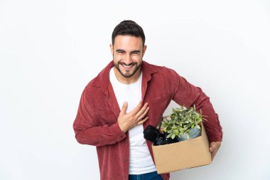 Beyaz arka planda izole edilmiş eşyalarla dolu bir kutuyu alırken beyaz bir adam hamle yapıyor.