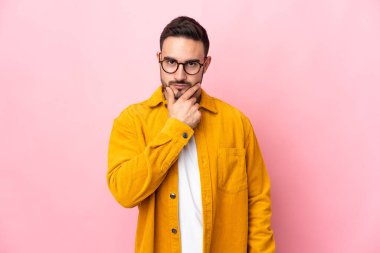 Pembe arka planda soyutlanmış beyaz, yakışıklı bir adam.