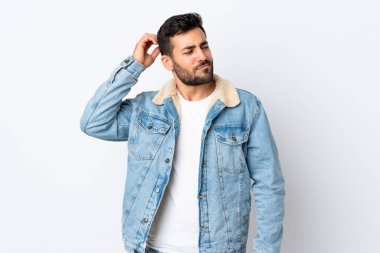 Beyaz arka planda sakallı, genç ve yakışıklı bir adam. Kafası kaşınırken şüpheleri var.