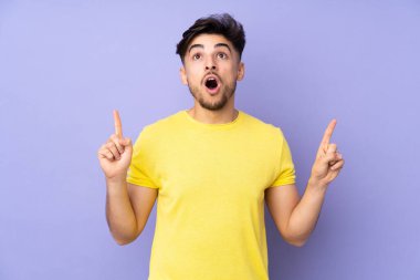 Münzevi geçmişi olan yakışıklı Arap bir adam şaşırmış ve yukarı bakıyor.