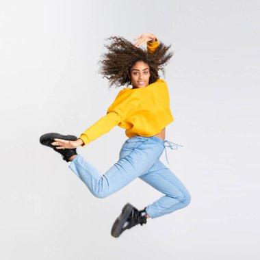 Genç Afrikalı Amerikalı kadın izole beyaz arka planda dans ediyor.