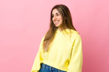 Soyutlanmış pembe arka planda genç bir kadın.