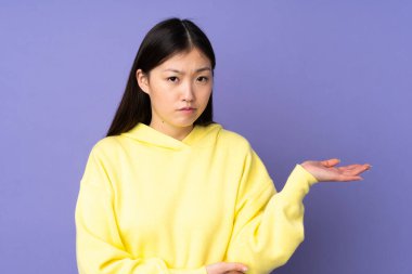 Mor arka planda izole edilmiş genç Asyalı kadının şüpheleri var.