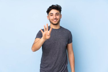 Soyutlanmış geçmişi olan yakışıklı Arap bir adam mutlu ve parmakları olan dört kişi sayıyor.