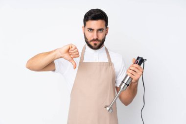 Beyaz arkaplanda izole edilmiş el blenderi kullanan adam baş parmak aşağı işareti gösteriyor