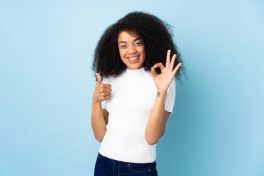 Tecrit edilmiş geçmişi olan genç Afrikalı Amerikalı bir kadın tamam işareti ve baş parmak hareketi gösteriyor.