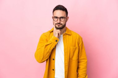 Pembe arka planda soyutlanmış beyaz, yakışıklı bir adam.