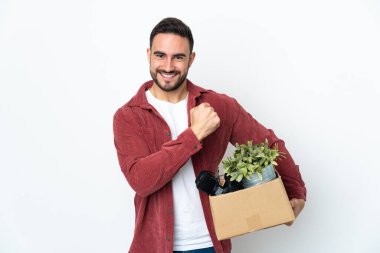 Beyaz arka planda izole edilmiş şeylerle dolu bir kutuyu alıp zaferi kutlayan beyaz bir adam hamle yapıyor.