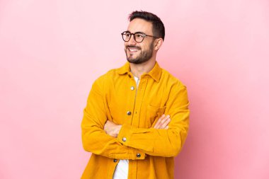 Beyaz tenli yakışıklı bir adam pembe arka planda izole edilmiş mutlu ve gülümsüyor.