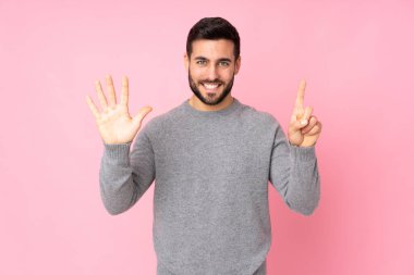 Kafkasyalı yakışıklı adam tecrit edilmiş arka planda altı parmaklı sayıyor.