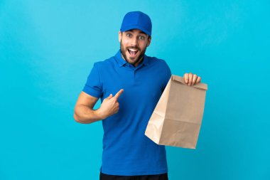 Mavi arka planda sakallı bir teslimatçı. Sürpriz yüz ifadesi var.