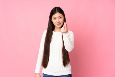 Asyalı genç bir kadın soyutlanmış bir şekilde para hareketi yapıyor.