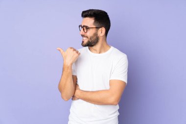 Kafkasyalı yakışıklı, soyutlanmış bir geçmişi olan bir adam bir ürün sunmak için kenarı işaret ediyor.