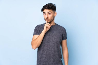 Münzevi bir geçmişi olan Arap yakışıklı bir adam sessizlik işareti gösteriyor. Parmağını ağzına sokuyor.