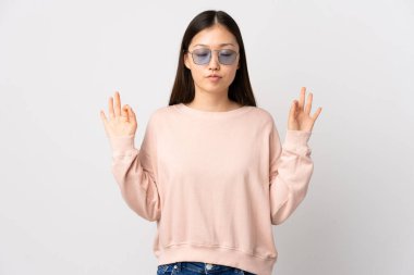 Zen pozisyonunda, izole edilmiş beyaz arka planı olan genç bir Çinli kız.