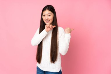 Tecrit edilmiş bir geçmişi olan genç Asyalı kadın bir ürünü sunmak için kenarı işaret ediyor.