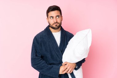 Genç adam pembe arka planda izole bir şekilde uyuyacak.