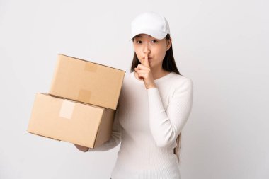 Genç teslimatçı Çinli kadın izole edilmiş beyaz arka planda sessizlik jesti yapıyor.