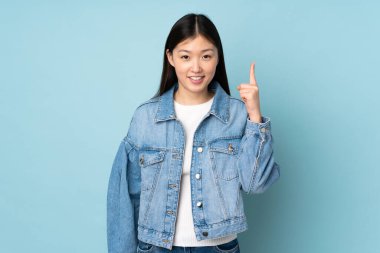 Arka planda izole edilmiş genç Asyalı kadın harika bir fikre işaret ediyor.