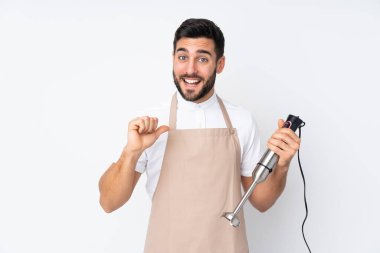 Beyaz arka planda izole edilmiş, gururlu ve kendini beğenmiş el blenderi kullanan bir adam.