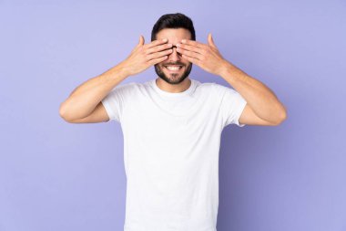 Kafkasyalı yakışıklı adam soyutlanmış arka planda gözlerini kapıyor ve gülümsüyor.