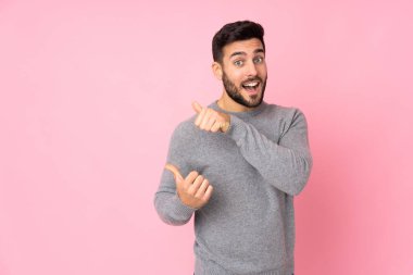 Kafkasyalı yakışıklı, soyutlanmış bir geçmişi olan bir adam bir ürün sunmak için kenarı işaret ediyor.