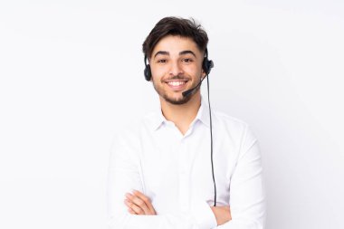 Beyaz arka planda izole edilmiş kulaklıkla çalışan pazarlamacı Arap adam gülüyor.