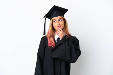 Genç üniversite mezunu izole edilmiş beyaz arka planda gülümserken yukarı bakıyor