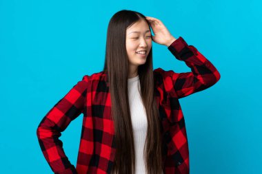 Soyutlanmış mavi arka planda genç bir Çinli kız gülümsüyor.