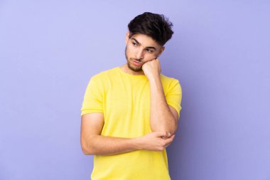 Yorgun ve sıkılmış ifadesiyle soyutlanmış Arap yakışıklı bir adam.