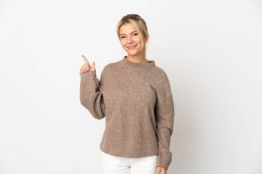Beyaz arka planda izole edilmiş genç bir Rus kadın en iyinin işareti olarak parmağını kaldırıyor ve gösteriyor.