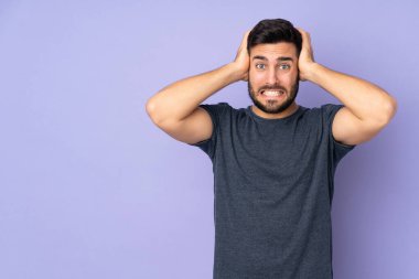 Kafkasyalı yakışıklı, mor arka planda sinir bozucu hareketler yapıyor.