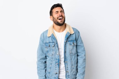 Beyaz arka planda sakallı yakışıklı genç adam gülüyor.