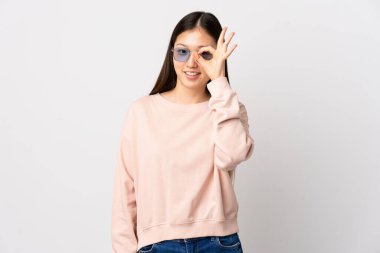 Genç Çinli kız izole edilmiş beyaz arka planda parmaklarıyla işaret veriyor.