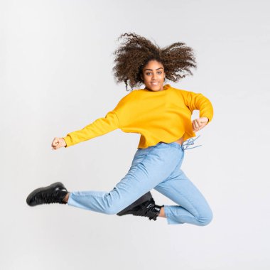 Genç Afrikalı Amerikalı kadın izole beyaz arka planda dans ediyor.