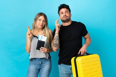 Kafkasyalı genç çift mavi arka planda izole bir şekilde seyahat edecek.