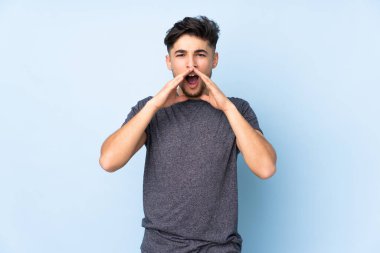 Arap yakışıklı adam izole edilmiş arka planda bağırıyor ve bir şey duyuruyor.