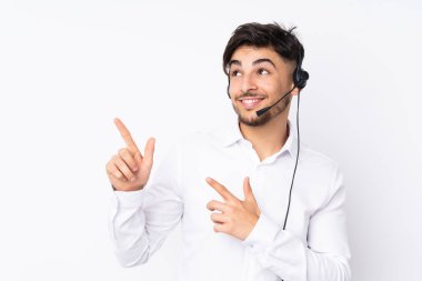 Beyaz arka planda izole edilmiş kulaklıkla çalışan pazarlamacı Arap adam işaret parmağıyla işaret etmek harika bir fikir.