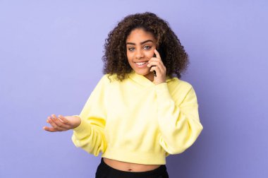 Genç Afrikalı Amerikalı kadın arka planda izole edilmiş. Cep telefonuyla biriyle sohbet ediyor.