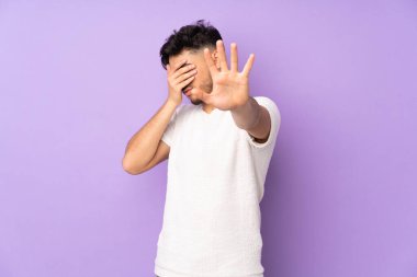 Soyutlanmış geçmişi olan yakışıklı Arap bir adam jesti durduruyor ve yüzünü kapatıyor.