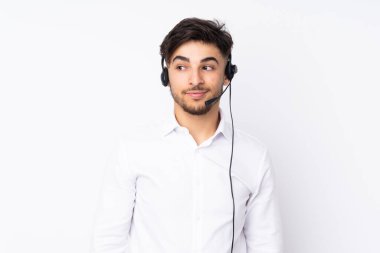 Tele pazarlamacı Arap bir adam beyaz arka planda izole edilmiş bir kulaklıkla çalışıyor.