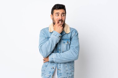 Sakallı genç yakışıklı adam beyaz arka planda izole edilmiş gergin ve korkmuş.