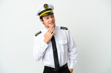 Rus uçak pilotu beyaz arka planda izole edilmiş, gülümserken yukarı bakıyor.