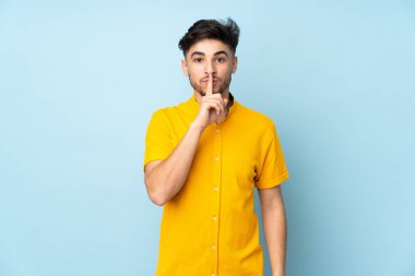 Münzevi bir geçmişi olan Arap yakışıklı bir adam sessizlik işareti gösteriyor. Parmağını ağzına sokuyor.